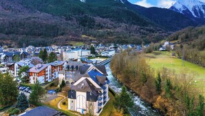 A town with a river, mountains, and a mix of residential and commercial buildings.