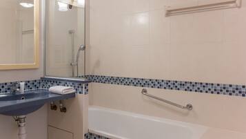 A bathroom with a sink, mirror, and bathtub.