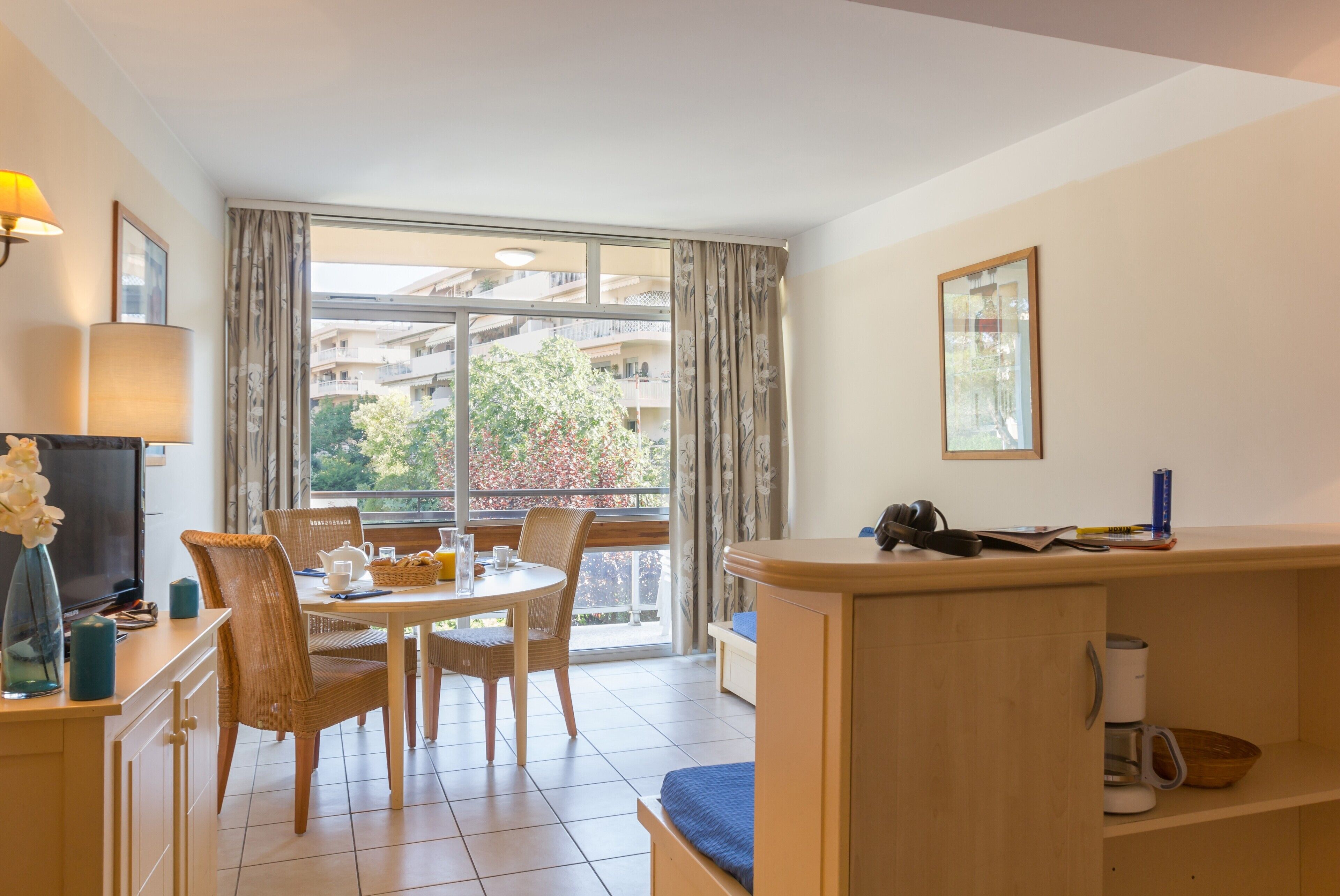 Un salon moderne avec un coin repas, de grandes fenêtres et un balcon.