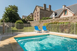 Piscine extérieure en saison, chaises longues