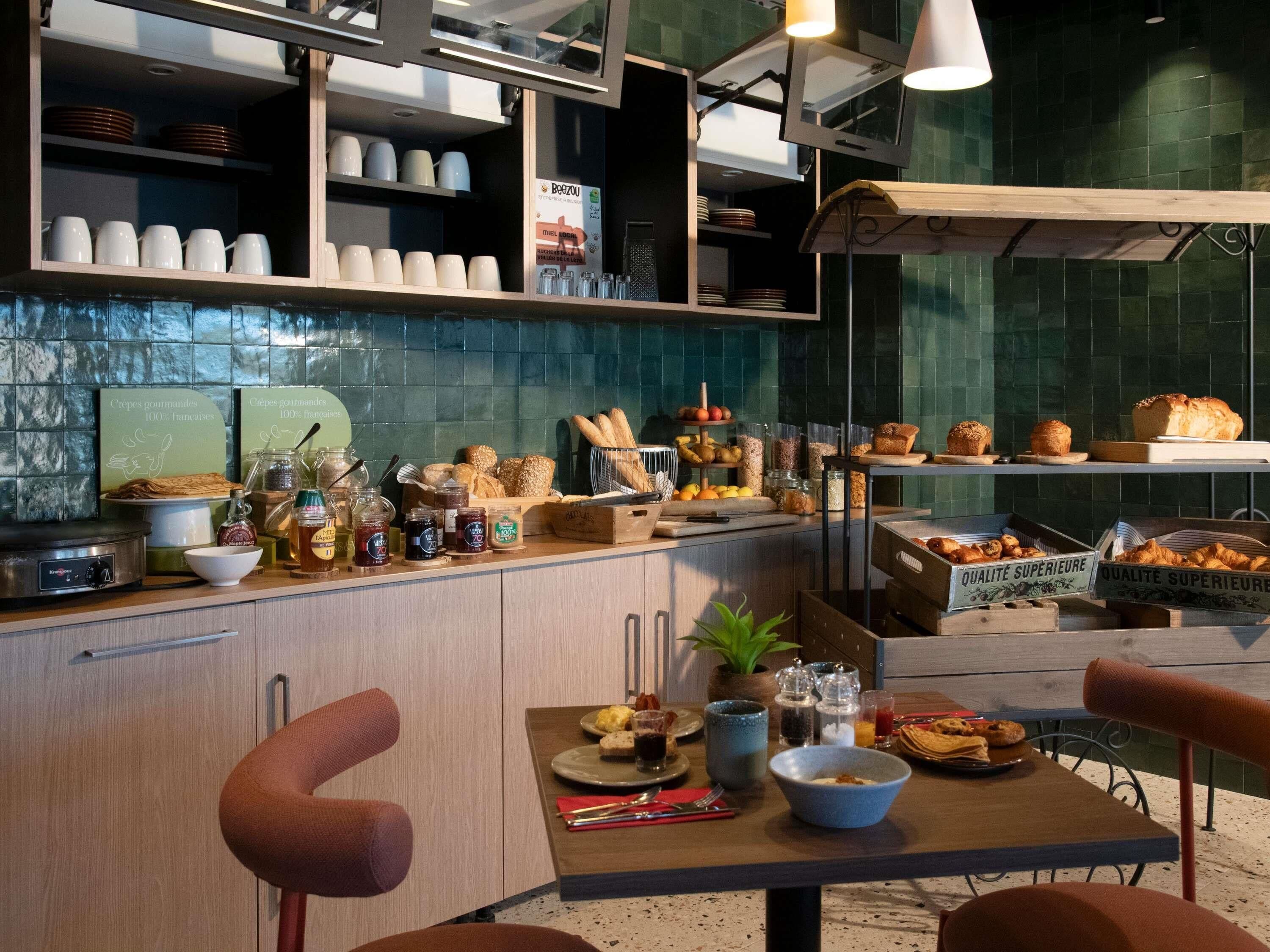 A breakfast buffet with various pastries, bread, and condiments.