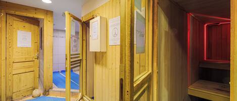 A sauna room with wooden walls, a bench, and a blue mat on the floor.