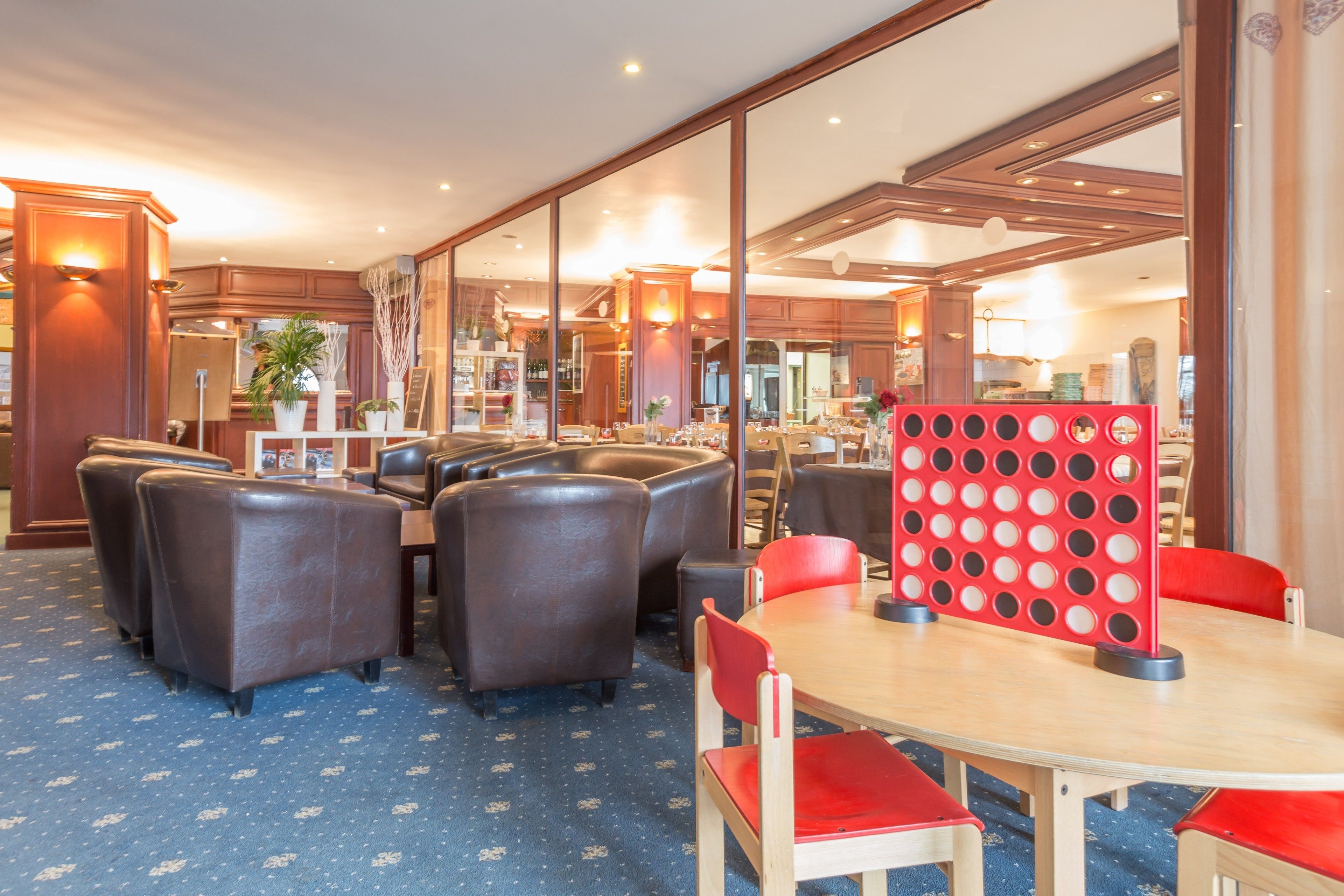 A hotel dining area with leather booths and a red partition.