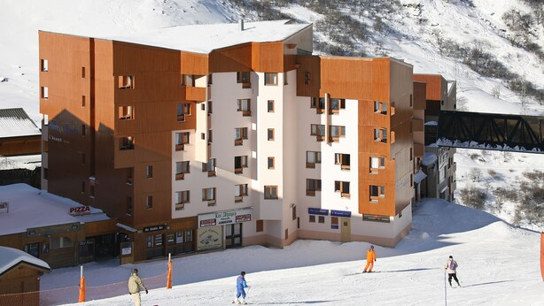 A multi-story hotel with a ski slope in the background. - Pierre & Vacances Residence Aconit (Les Belleville)