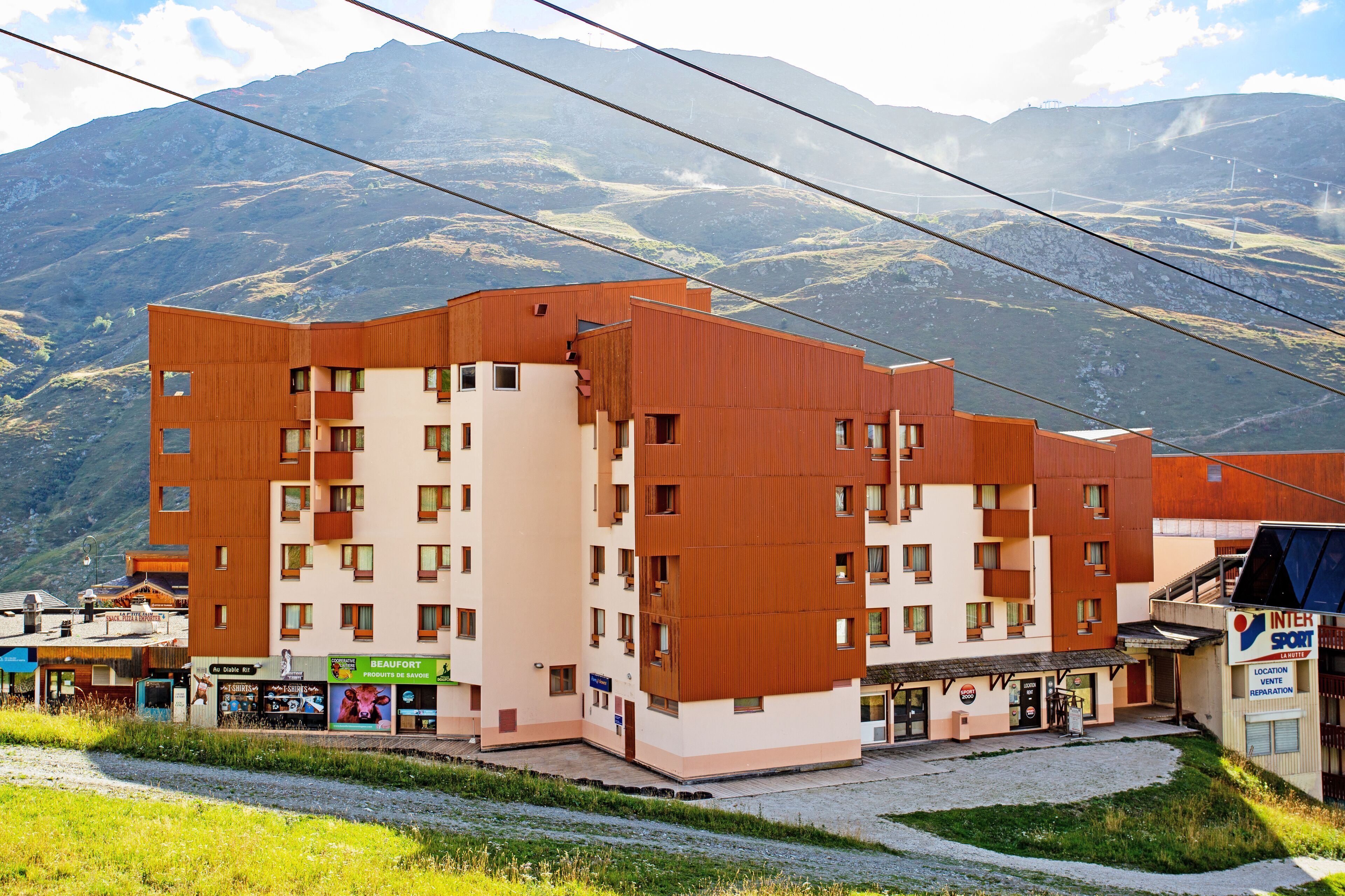 Un hôtel à plusieurs étages, doté d’un design moderne, avec des balcons et une cour intérieure.