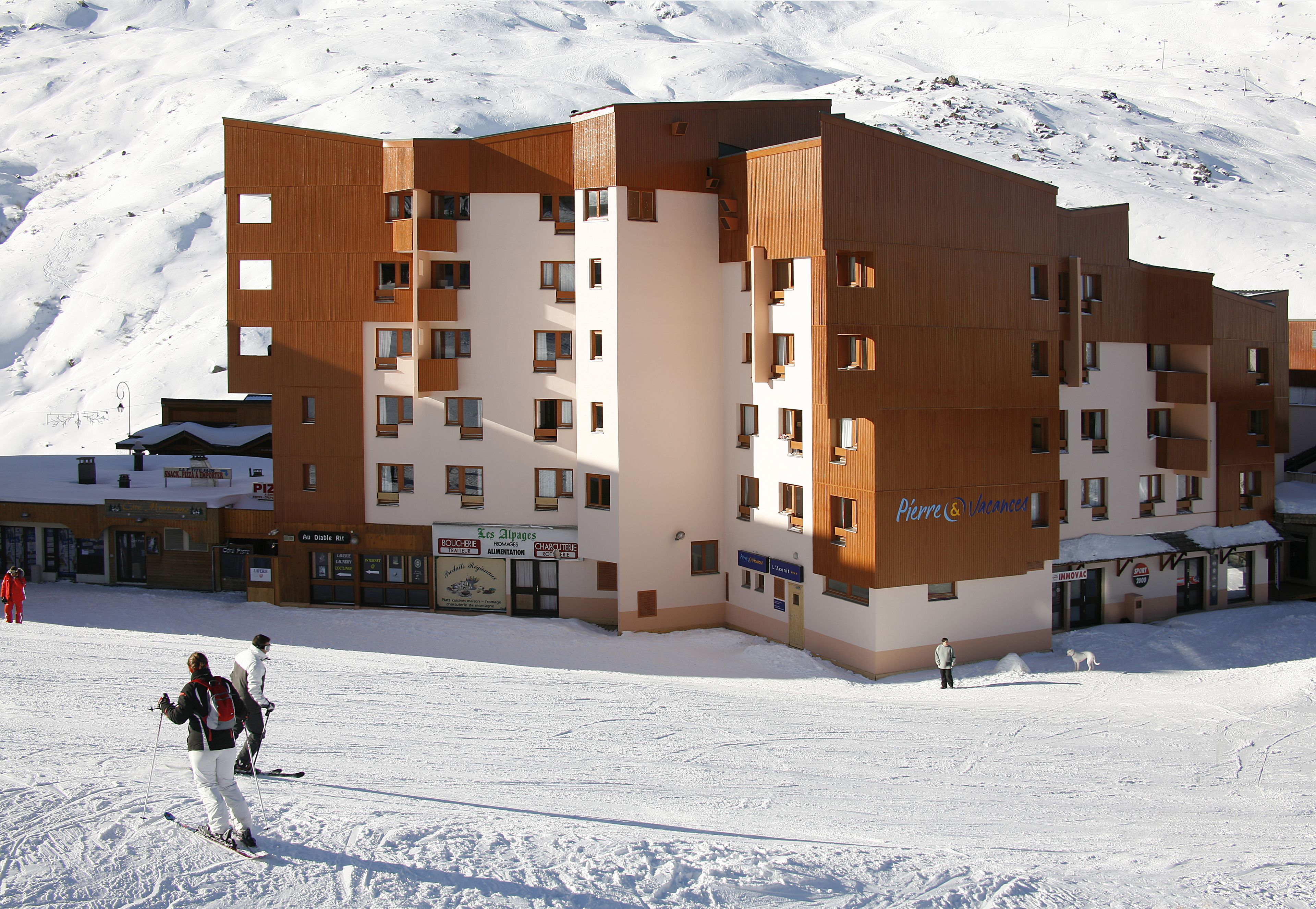 Un hôtel à plusieurs étages avec une piste de ski en arrière-plan.