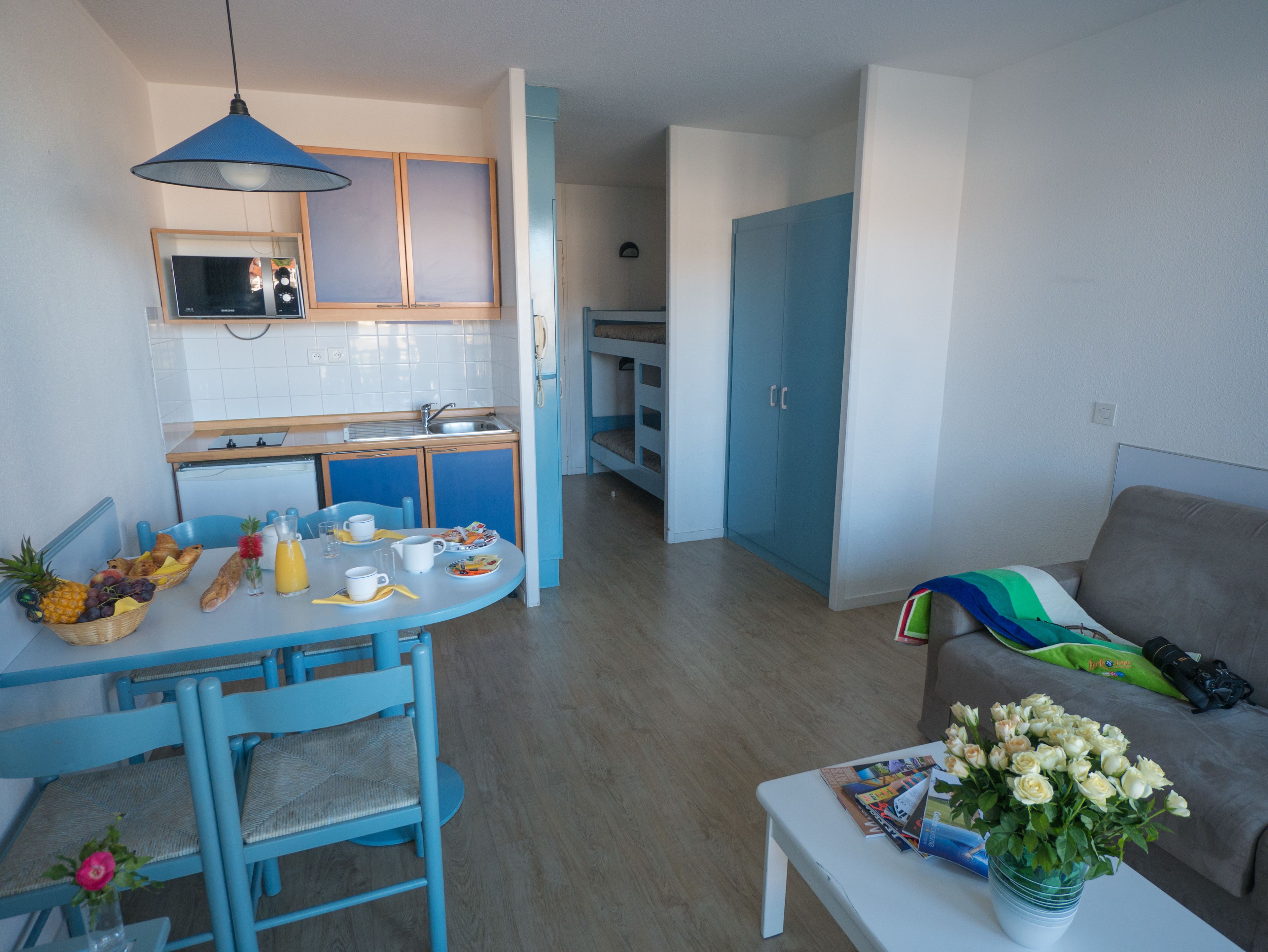 Un espacio habitable pequeño con kitchenette, comedor y sofá.