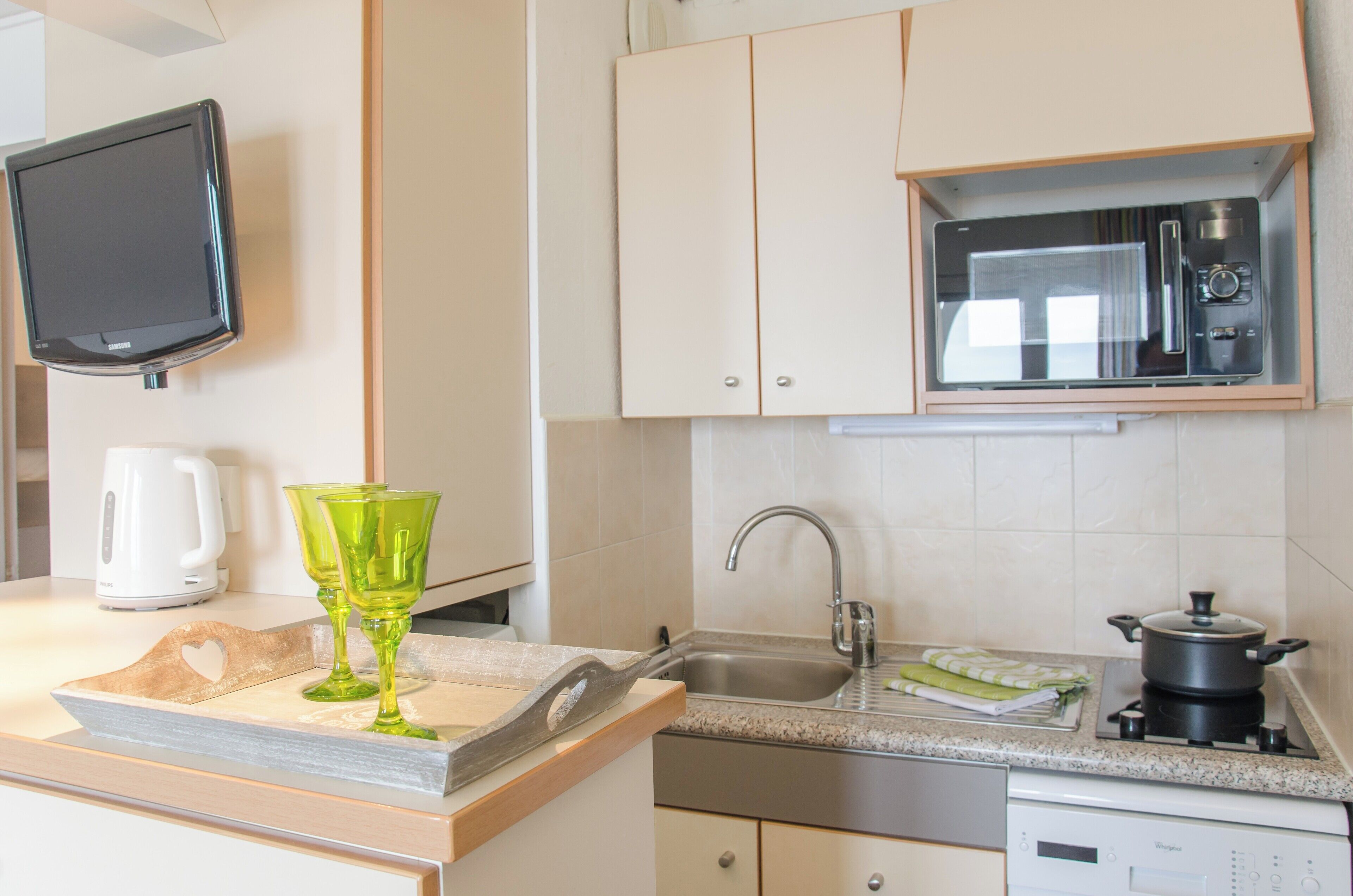 A kitchen with a microwave, sink, and a coffee maker.