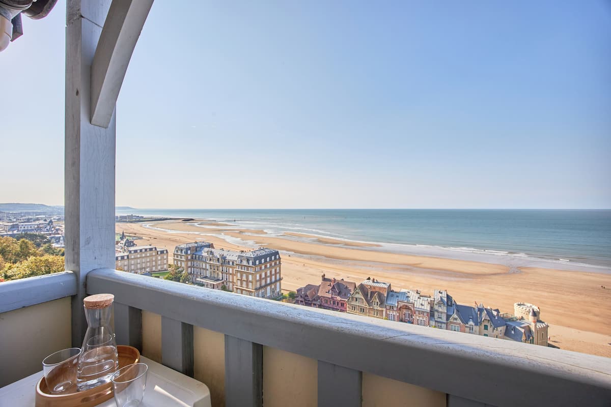 A balcony with a view of a beach and buildings.