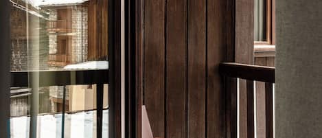 A wooden interior with a view of a snowy mountain landscape through a large window.
