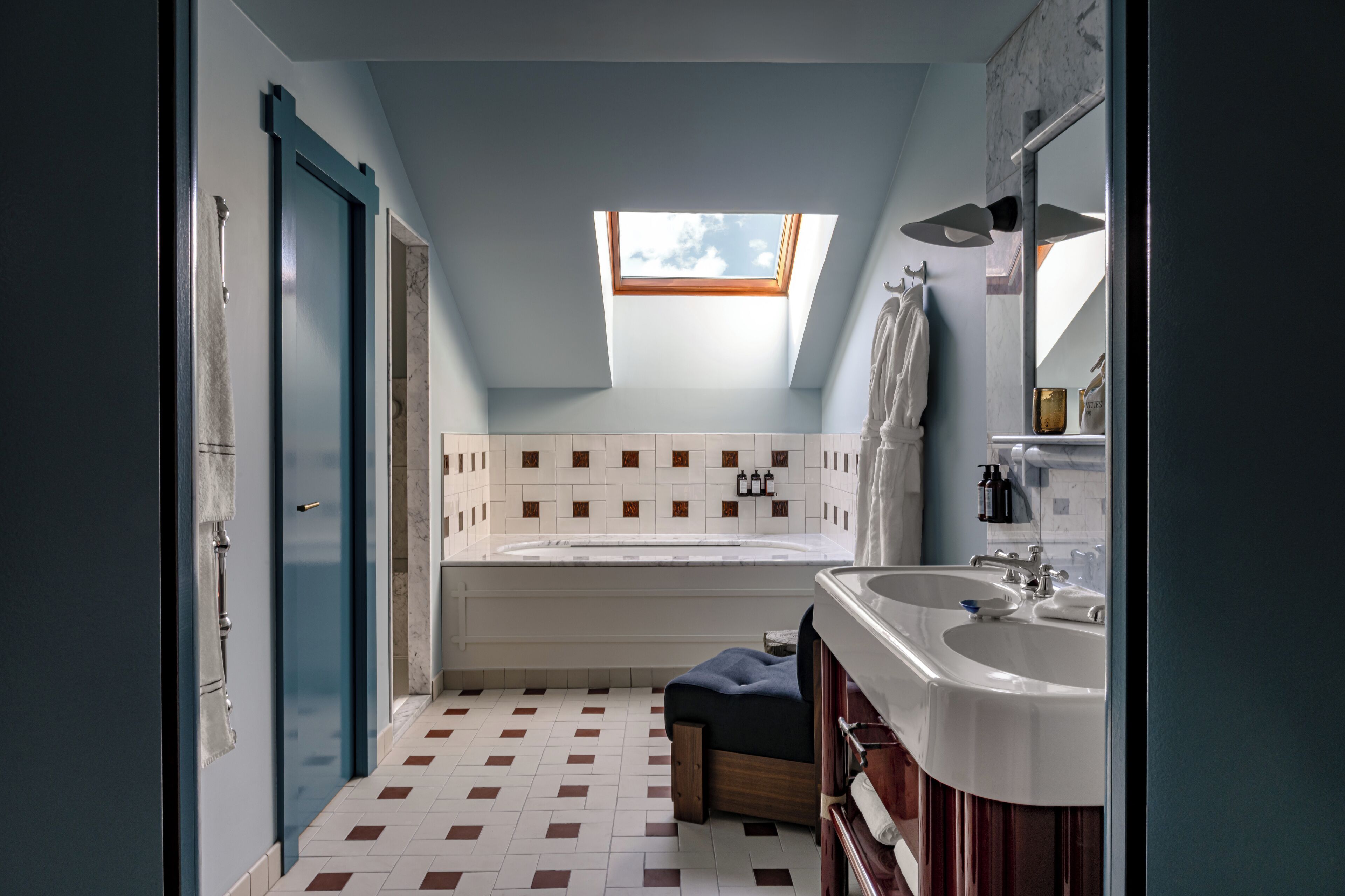 Ein modernes Badezimmer mit Oberlicht, einer Badewanne und zwei Waschbecken.