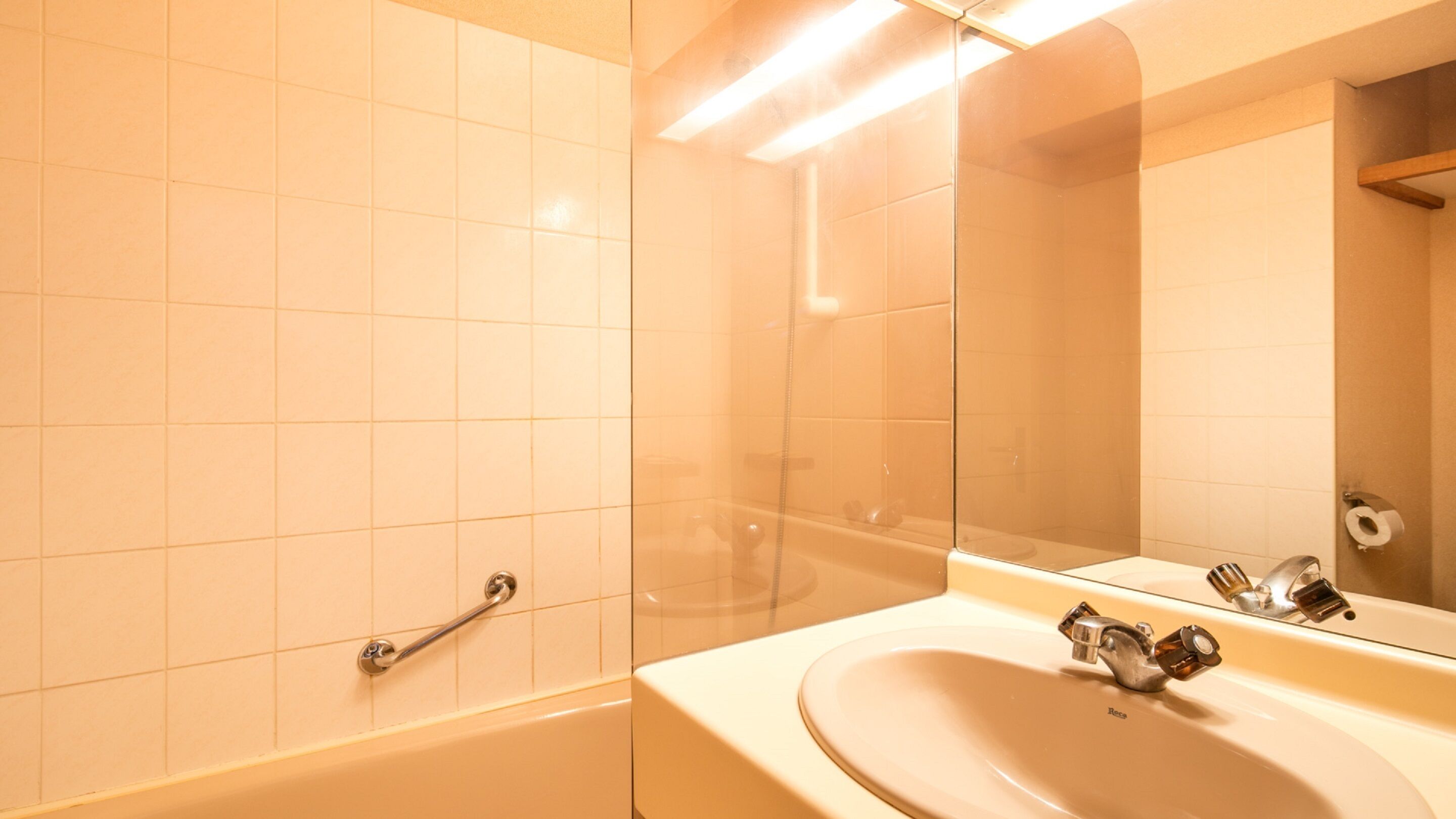 A bathroom with a bathtub, a sink, and a mirror.
