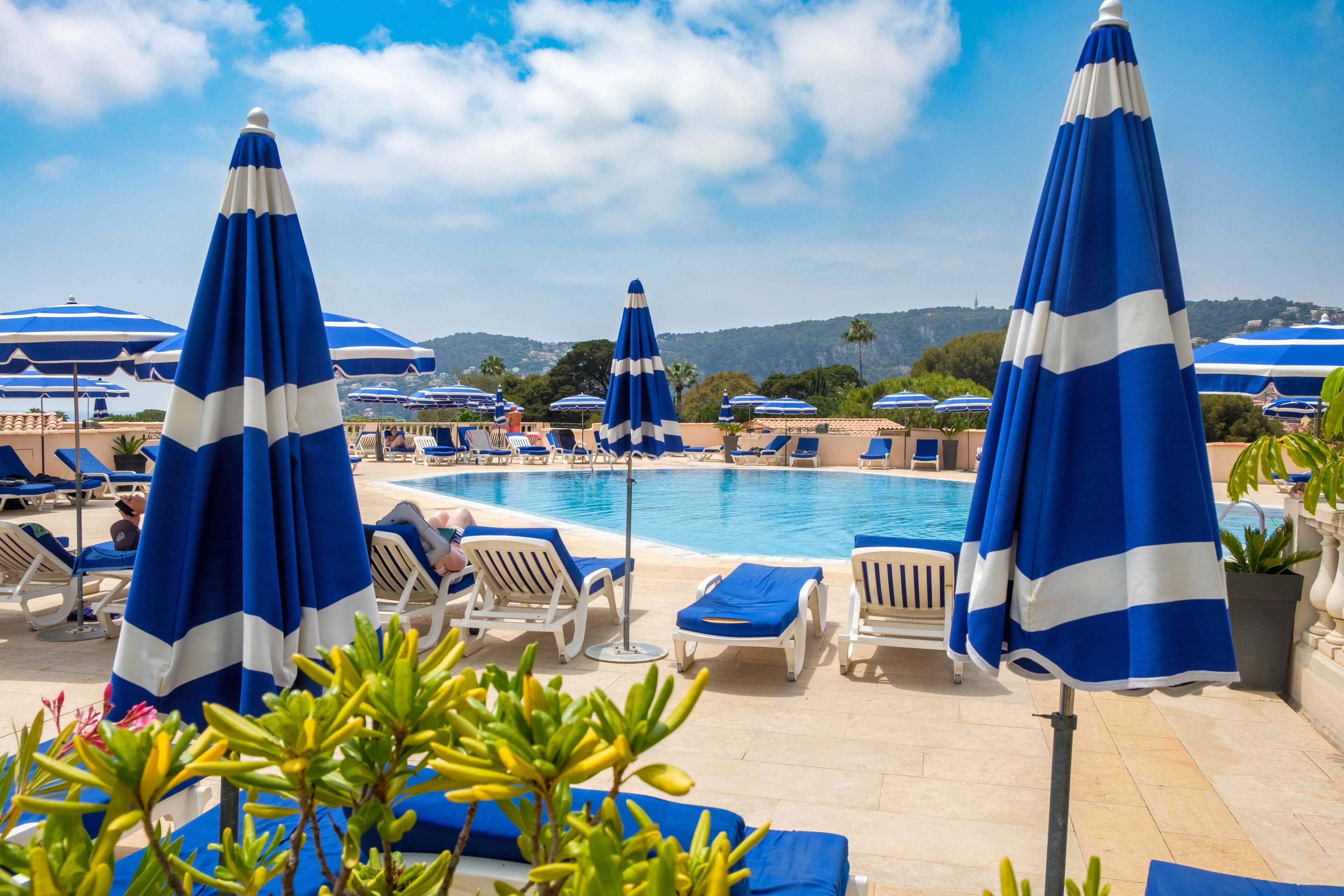Una piscina al aire libre de temporada, sombrillas