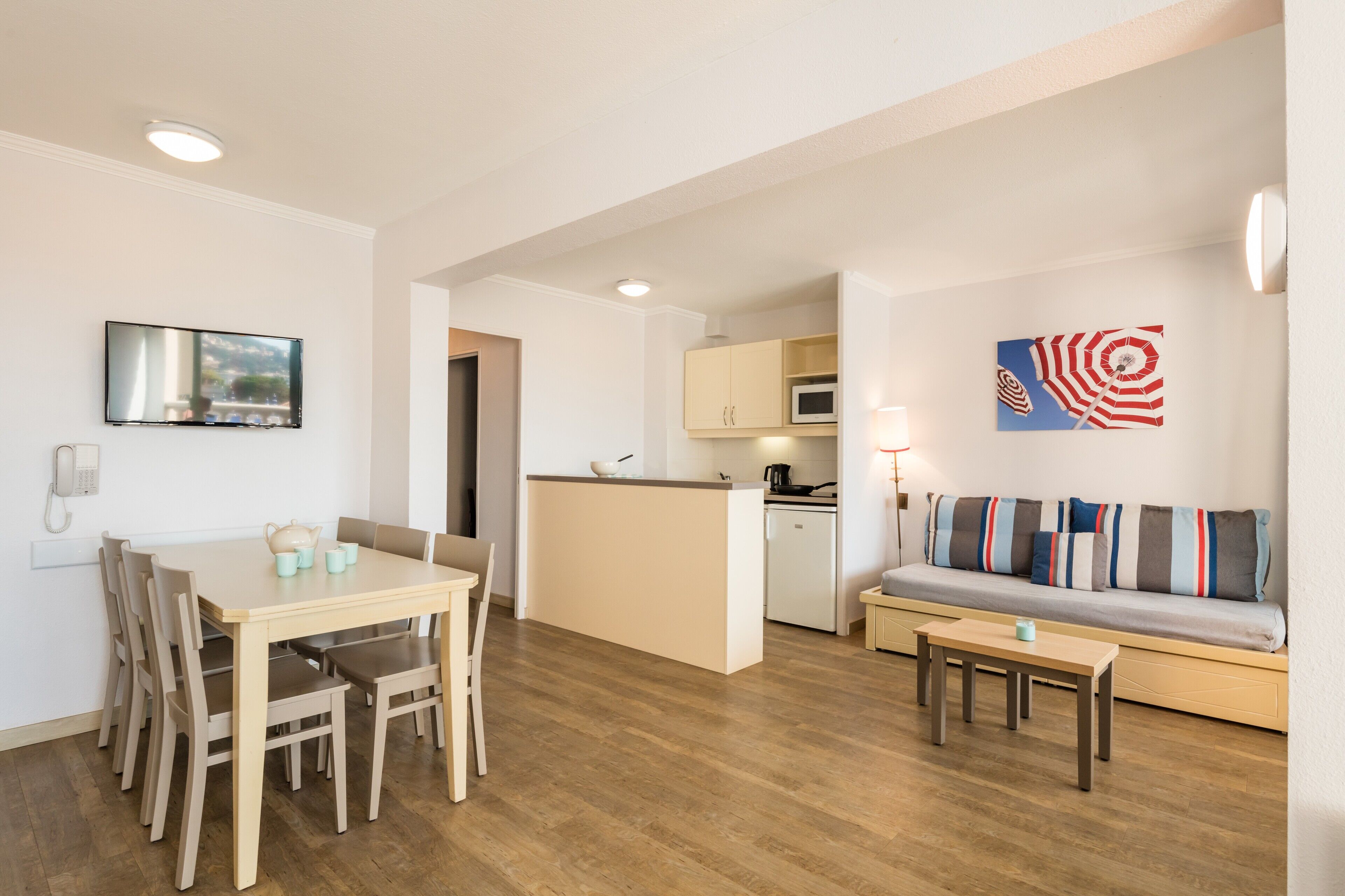 A compact living space with a dining area, kitchenette, and seating area.