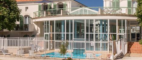 Un bâtiment doté d’une piscine, d’un patio couvert et d’une terrasse clôturée.