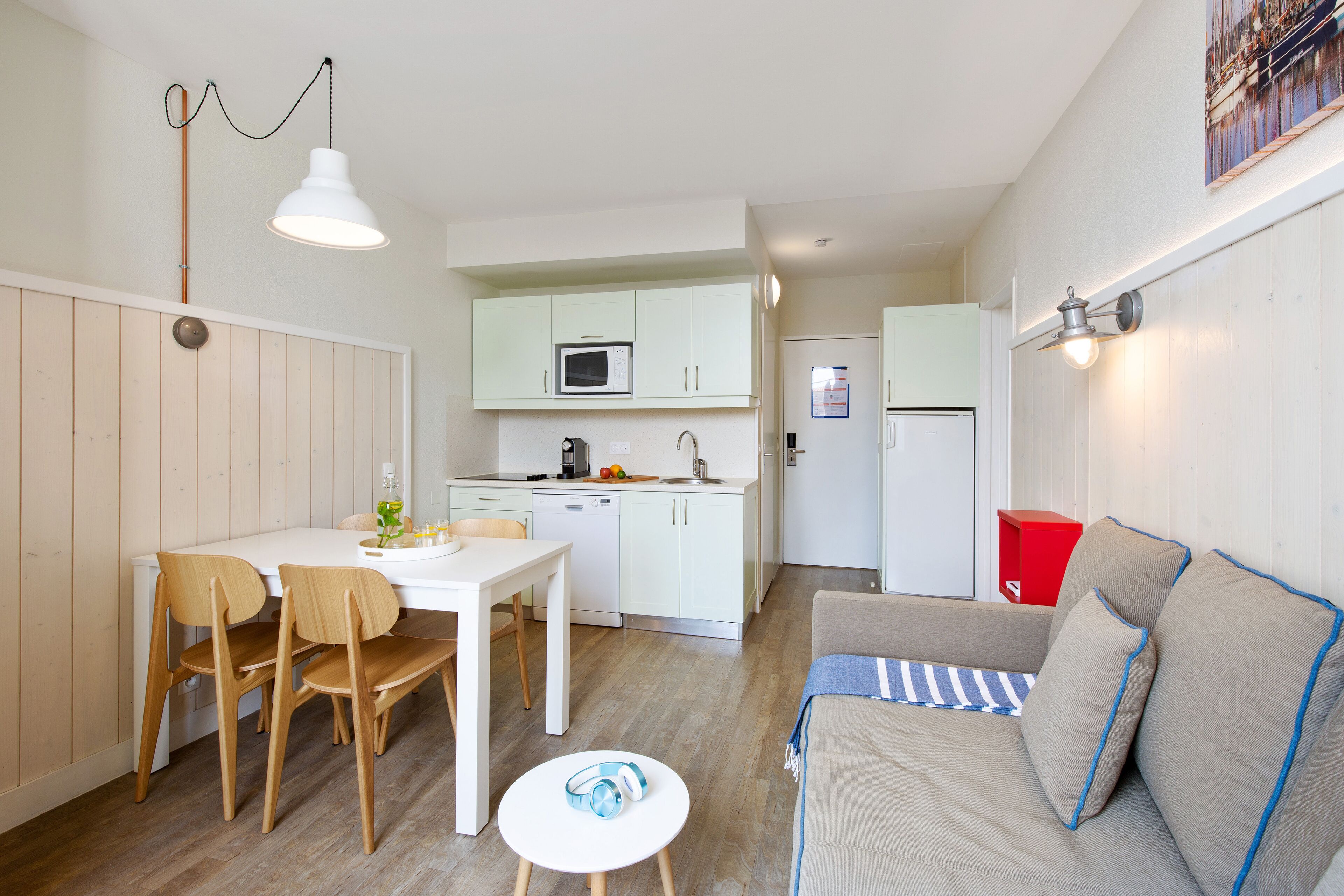 A compact living space with a dining area, kitchenette, and a sofa.