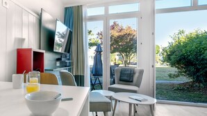 A modern kitchen with a dining area, large windows, and a view of the outdoors. - Résidence Le Palais des Gouverneurs Pierre & Vacances (Saint-Martin-de-Re)