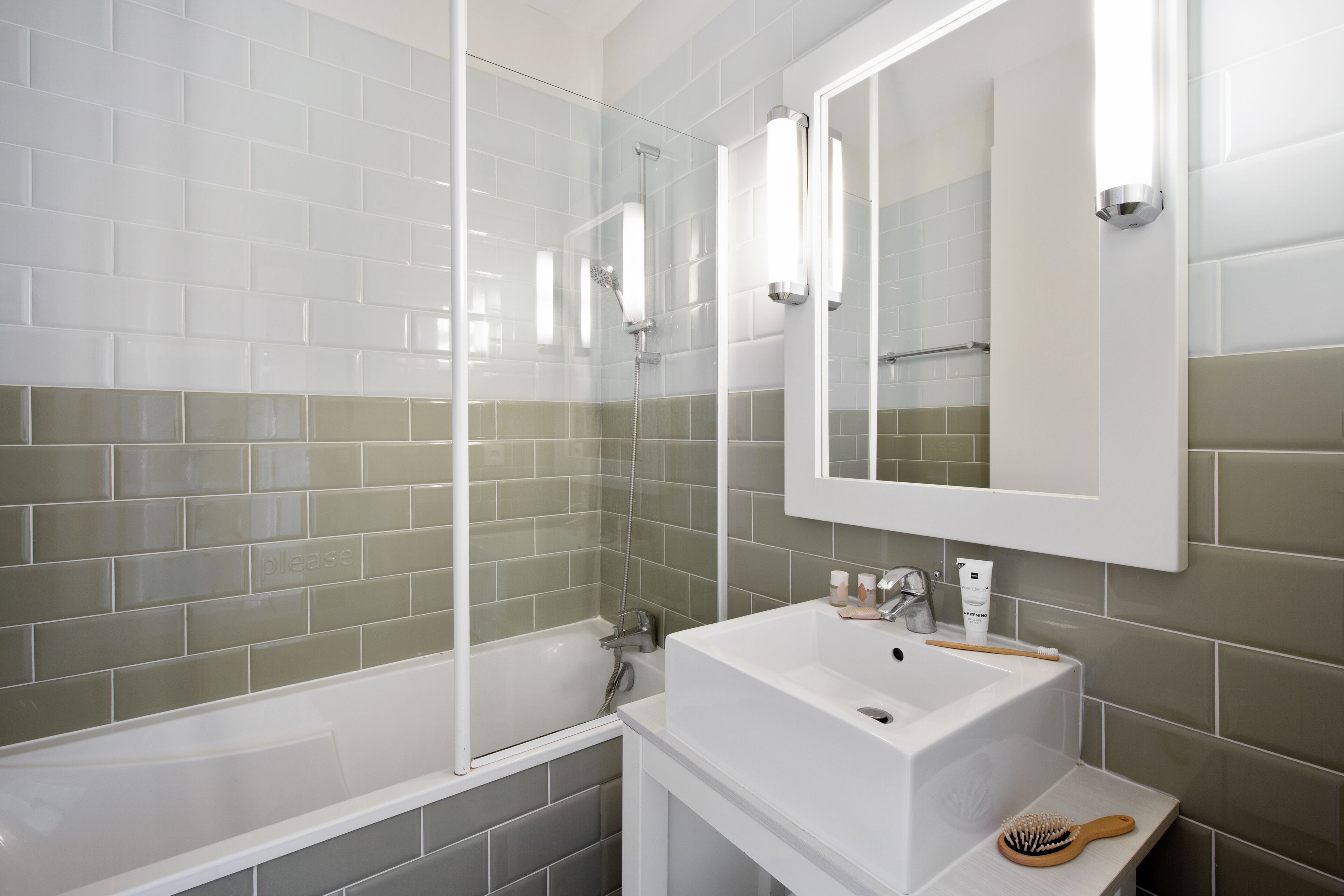 Un baño moderno con un lavabo blanco, un espejo y cabina de ducha.