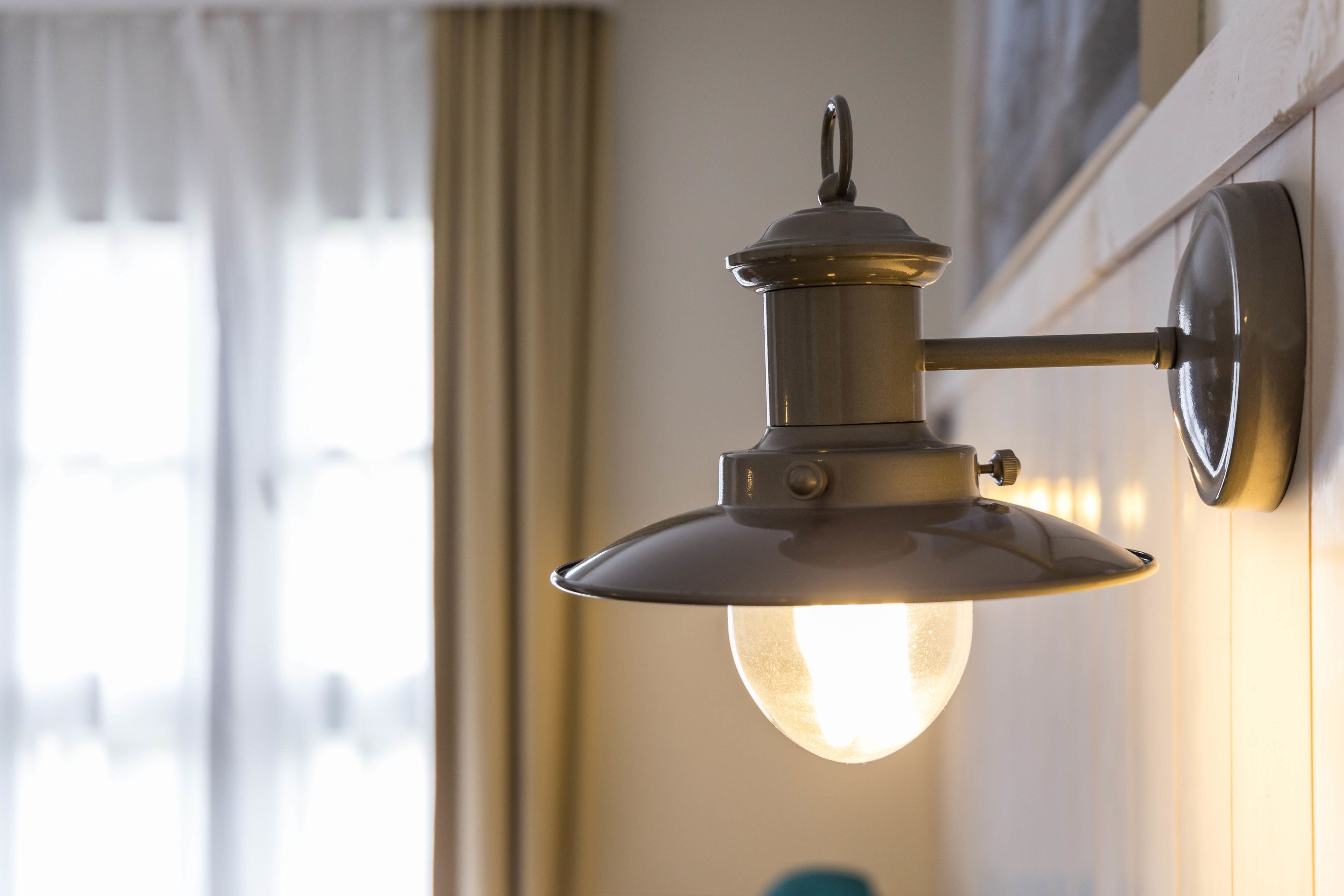 Eine Wandlampe mit freiliegender Glühbirne.