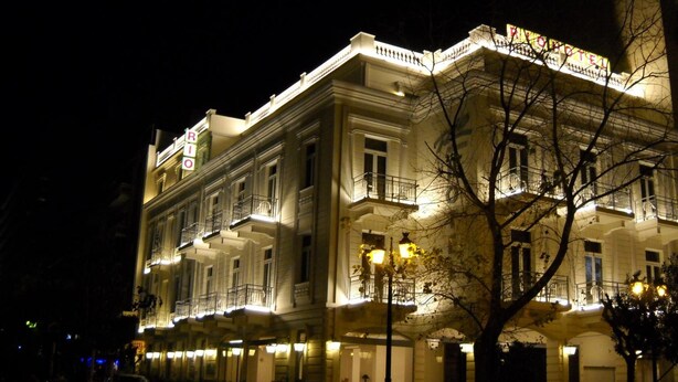 A historic building with multiple balconies and a sign indicating it is a hotel.