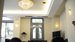 A modern lobby with a chandelier, a large window with a view, and a television.