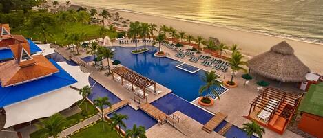Un resort con piscina, playa y vista al océano.