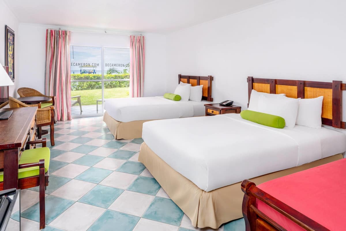 Een hotelkamer met twee bedden, een bureau en een stoel.