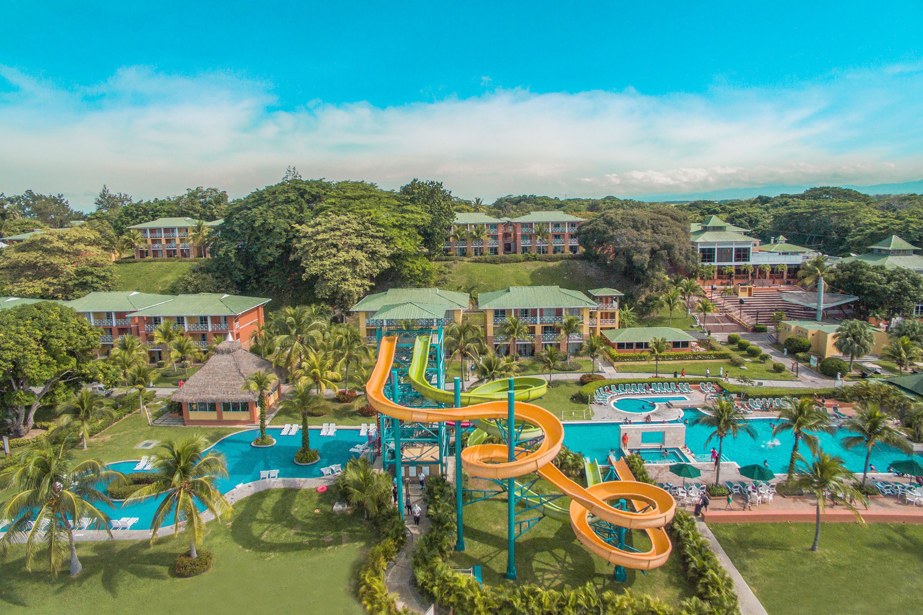 A resort with a water park, multiple swimming pools, and lush greenery.