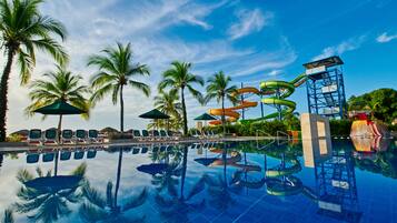 Relax by the pool surrounded by lounge chairs and umbrellas, with a water slide for all ages.