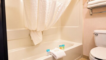Un baño con bañera, inodoro y cortina de ducha.