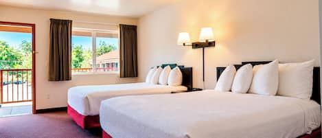 A hotel room with two beds, a balcony, and a view of greenery.