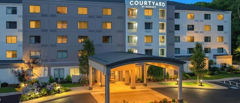 Un hôtel Courtyard by Marriott doté d’une entrée couverte, de plusieurs étages et d’une façade bien éclairée.