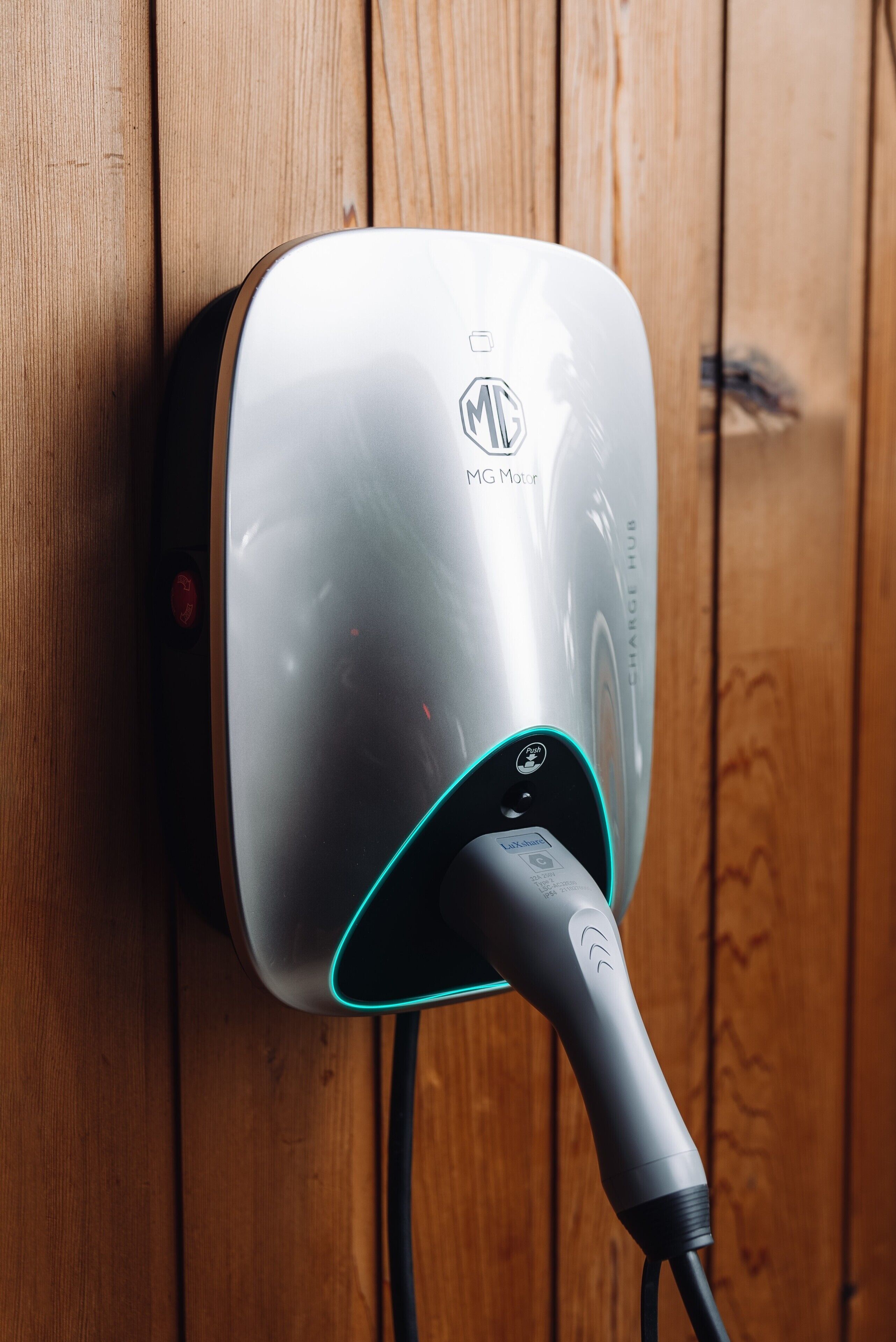 A wall-mounted charging station with a cable connected to it.