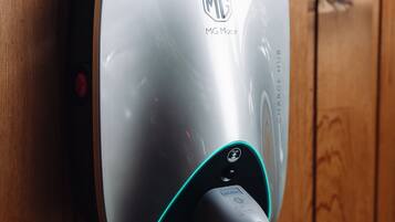 A wall-mounted charging station with a cable connected to it.