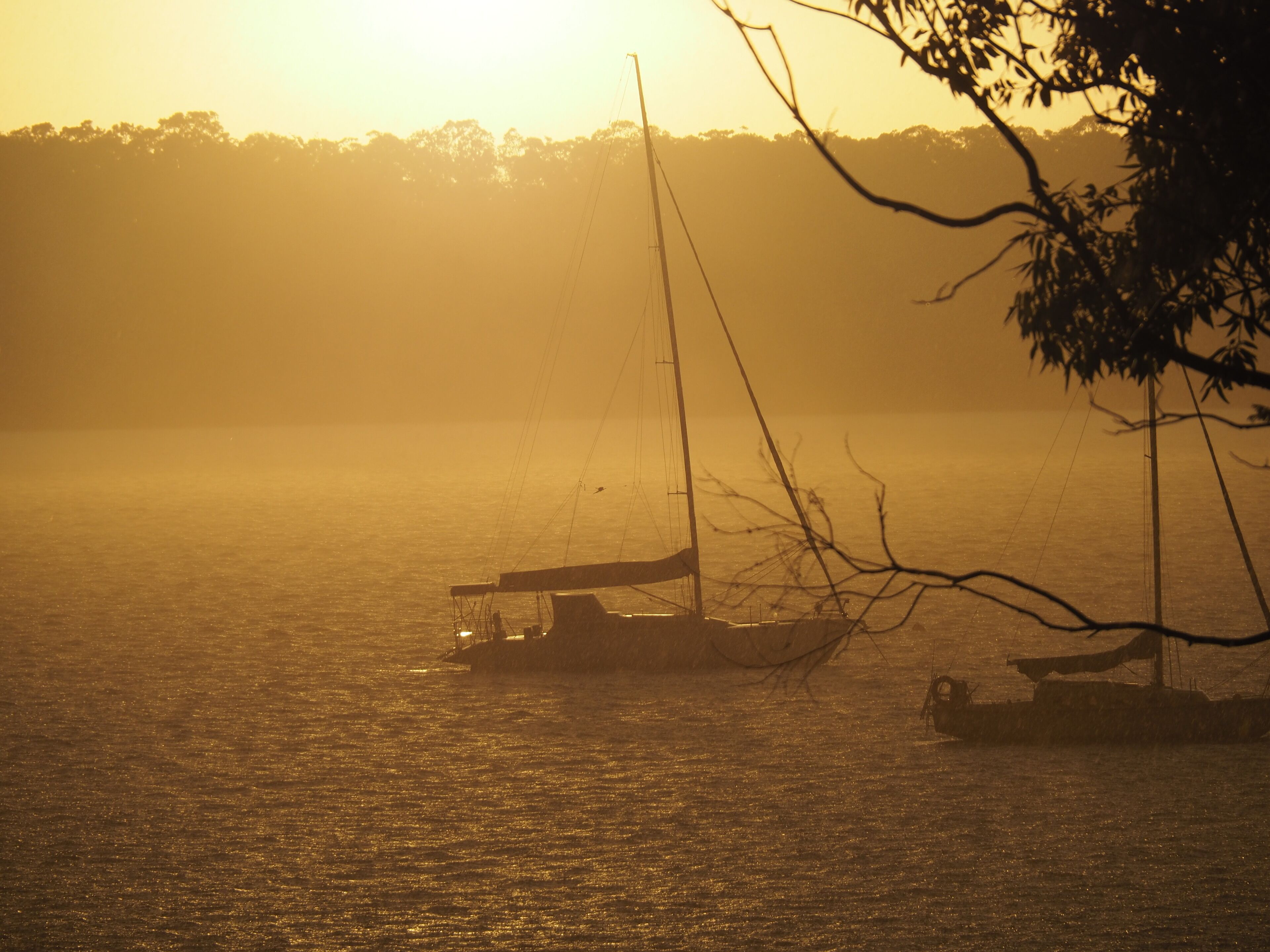 A calm body of water with boats and a distant shoreline.