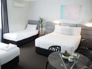 Habitación cuádruple Deluxe | Colchones con acolchado adicional y cortinas opacas