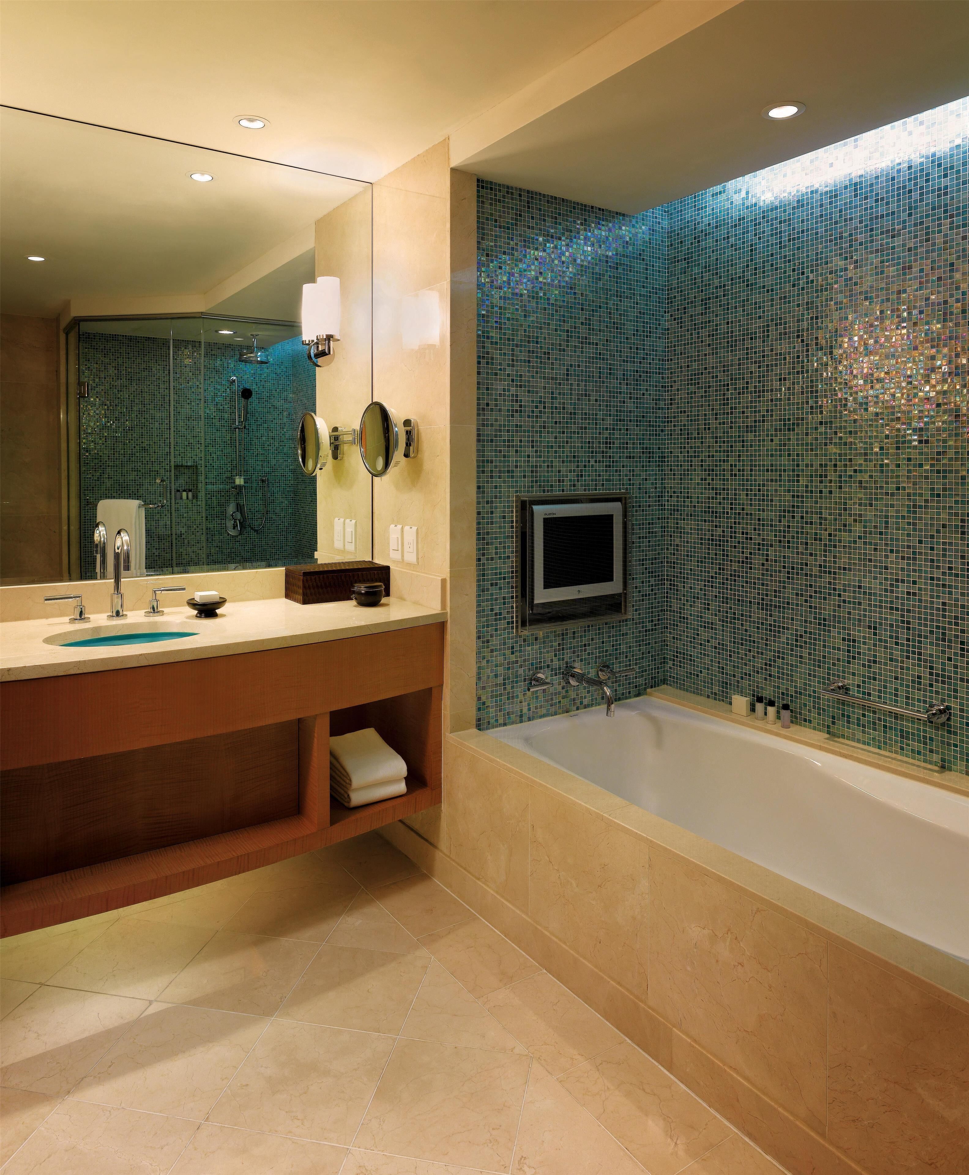 A modern bathroom with a large bathtub, a vanity with a mirror, and a shower area.