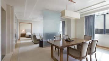Une chambre d’hôtel moderne dotée d’un coin repas, d’une grande fenêtre avec des rideaux et offrant une vue sur la ville.