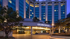 A hotel with a modern architectural design, featuring a prominent entrance and multiple floors.
