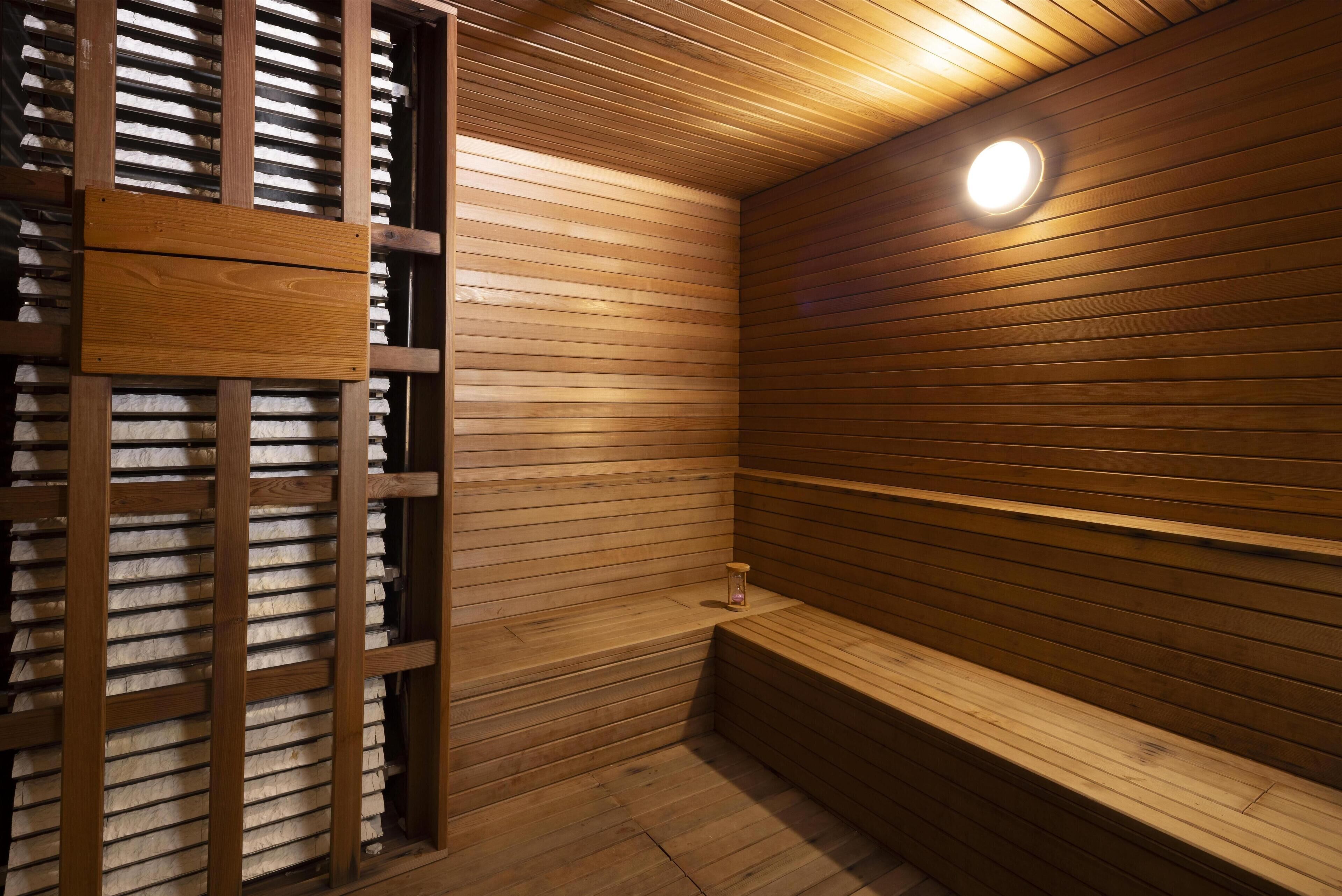 Un sauna avec des bancs en bois et un mur en bois à lattes.