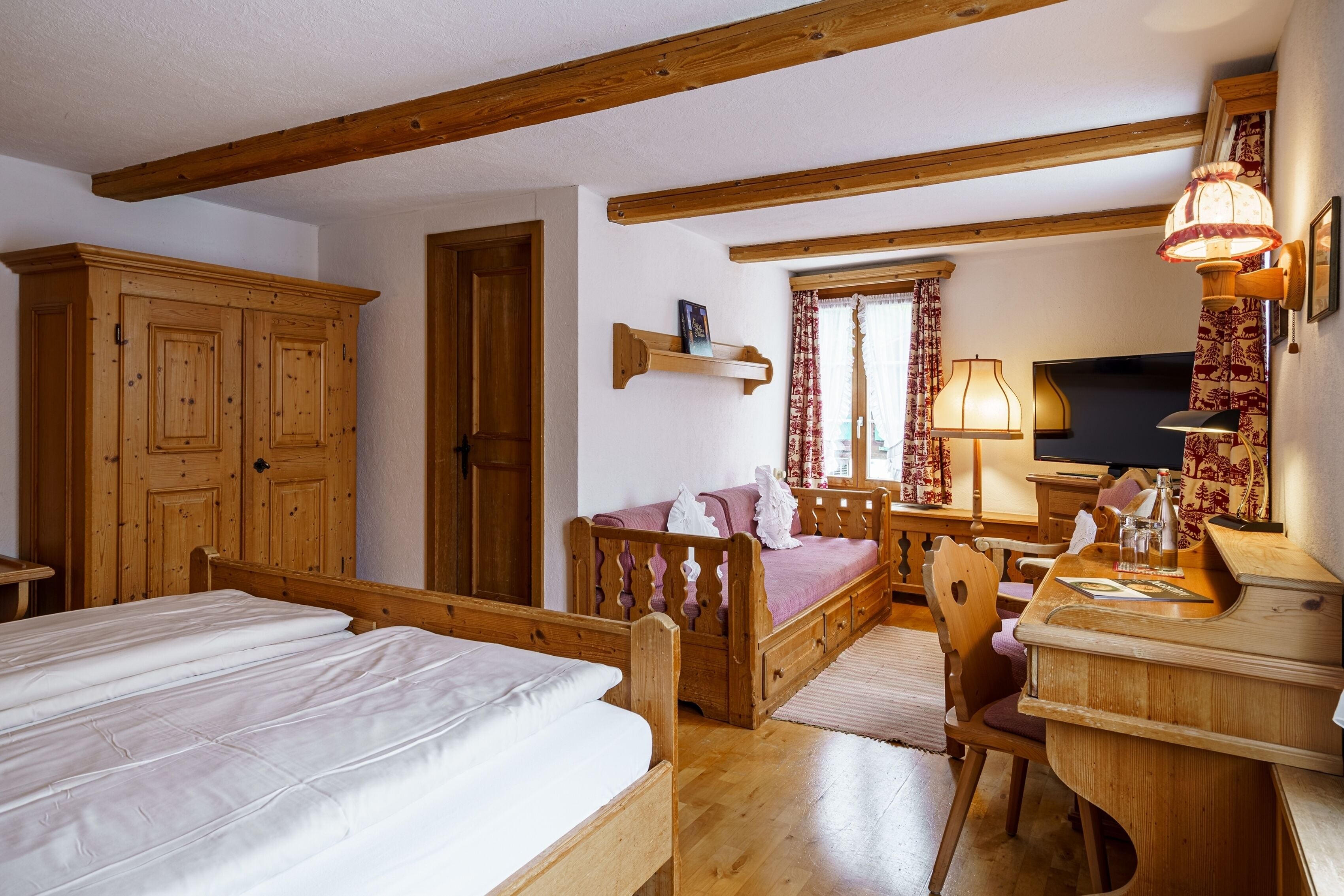 Una camera da letto in legno con letto, scrivania, sedia e armadio.
