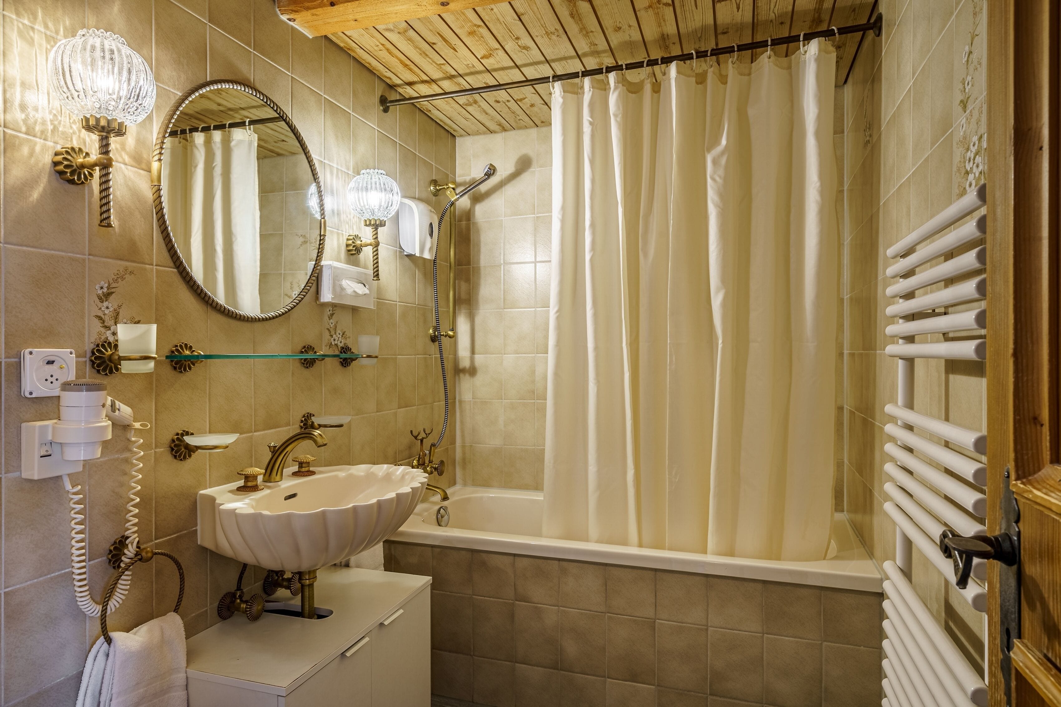 Ein Badezimmer mit Waschbecken, Spiegel, Dusche und Handtuchhalter.