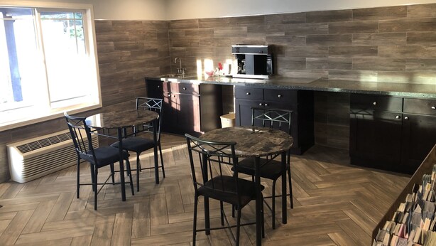 Una cocina moderna con armarios de madera oscura, microondas integrado y piso con patrón de espiga.