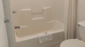 A bathroom with a bathtub, toilet, and shower curtain. - Shelaine Inn (Jeffersonville)