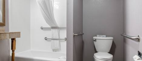 Un baño con bañera, inodoro y cortina de ducha.
