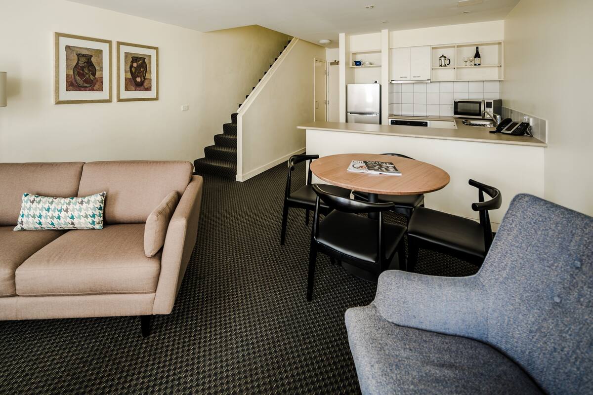 A compact living space with a sofa, a dining table, and a kitchenette.
