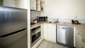 A modern kitchen with stainless steel appliances, including a refrigerator, microwave, oven, and dishwasher. - Salamanca Terraces (Battery Point)
