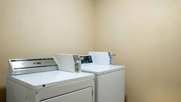 Une buanderie équipée de deux machines à laver blanches et d’un panneau de commande.