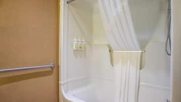 A bathroom with a bathtub, shower, and a towel rack.