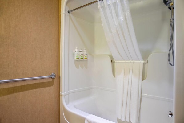 Un baño con bañera, ducha y un perchero para toallas.